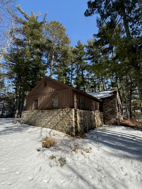 Rustic log cabin on a stone foundation in the snow