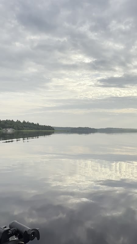 Golden sunset clouds mirrored on calm water at dusk